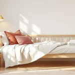 Small guest bedroom ideas — a warm-minimalist guest room with a daybed, layered bedding, folded towels, and a carafe